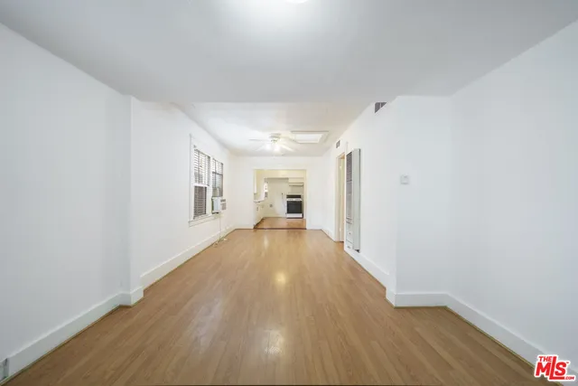 a view of a big room with wooden floor and windows