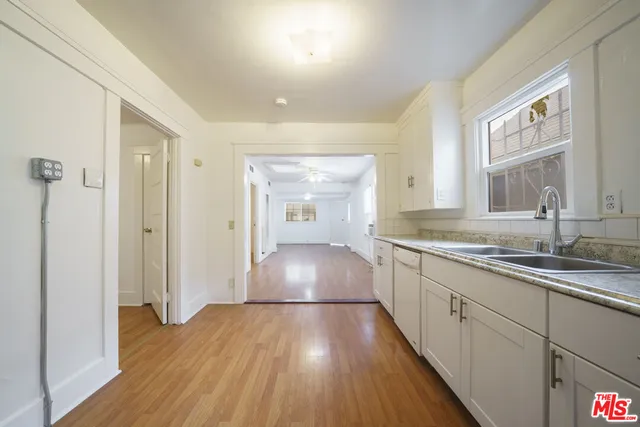 a kitchen with a sink and wooden floor