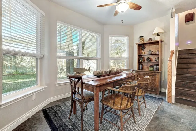 a large kitchen with granite countertop stools a sink stainless steel appliances and white cabinets