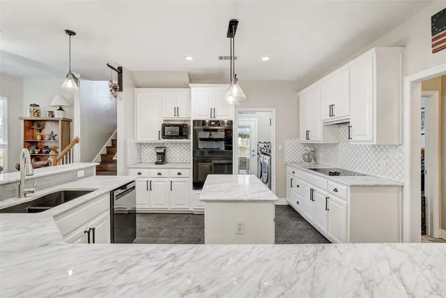 a kitchen with a sink a stove and chairs