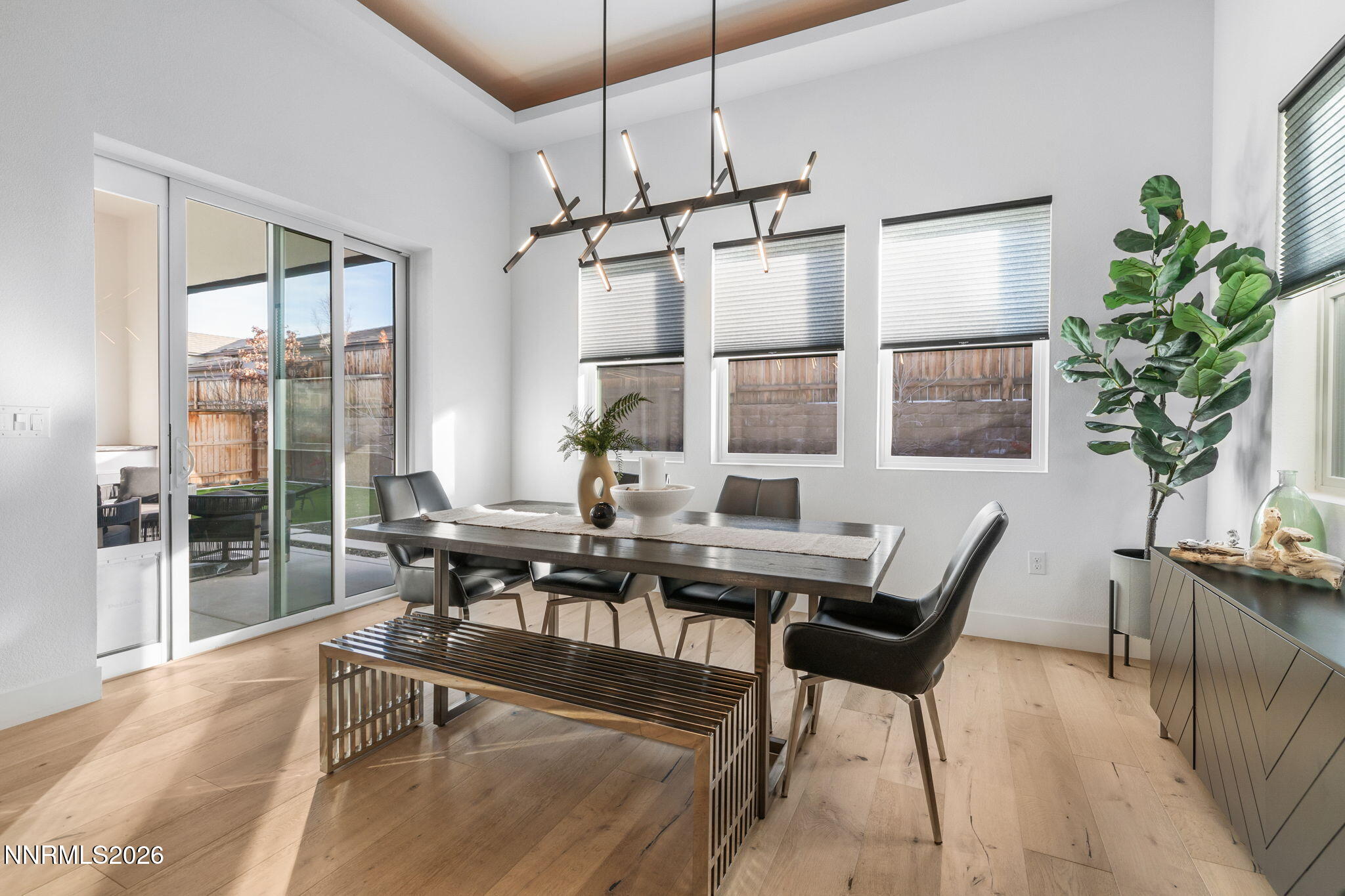 940 Little Star Drive Reno, NV 89511 - Photo 9 of 21 a dining room with wooden floor a chandelier a glass table and chairs