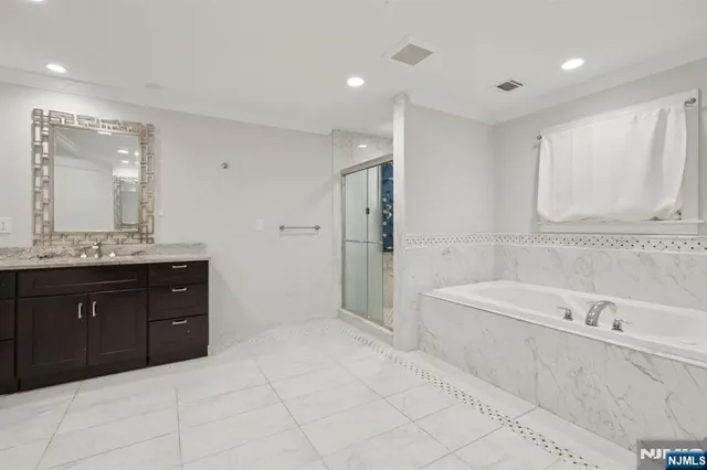 a bathroom with a tub sink and mirror