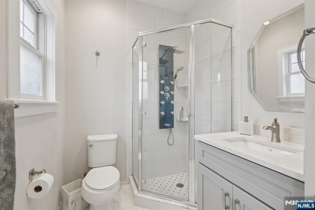 680 Soldier Hill Road Oradell, NJ 07649 - Photo 36 of 47 a bathroom with a sink a mirror a toilet and shower