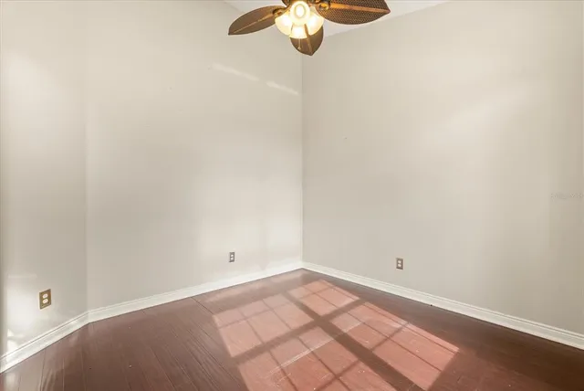 an empty room with a chandelier fan