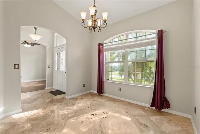 a view of a livingroom with a chandelier a bedroom and windows