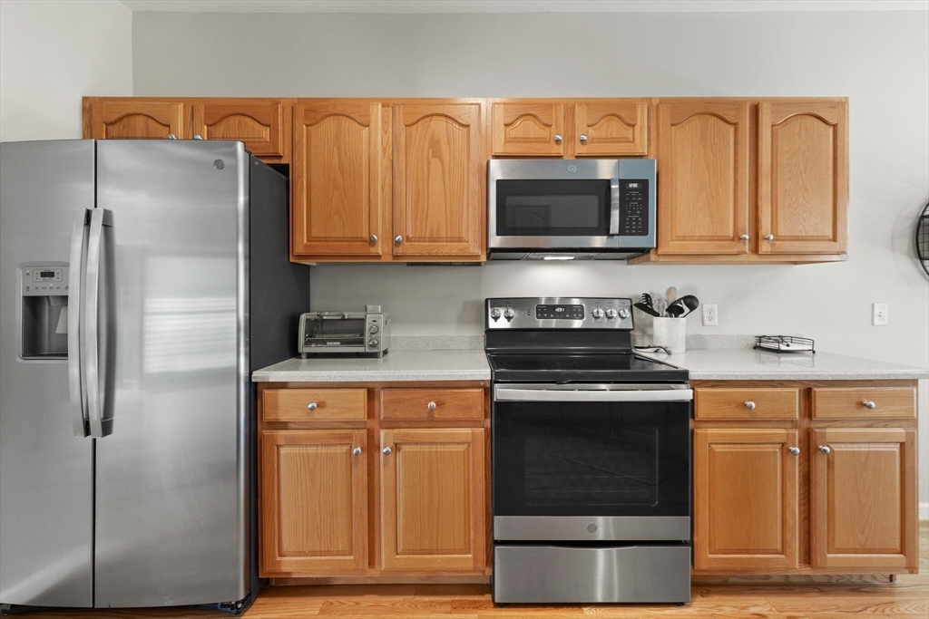27 Brook Lane, Unit 27 Berlin, MA 01503 - Photo 11 of 36 a kitchen with stainless steel appliances granite countertop a refrigerator and a stove top oven