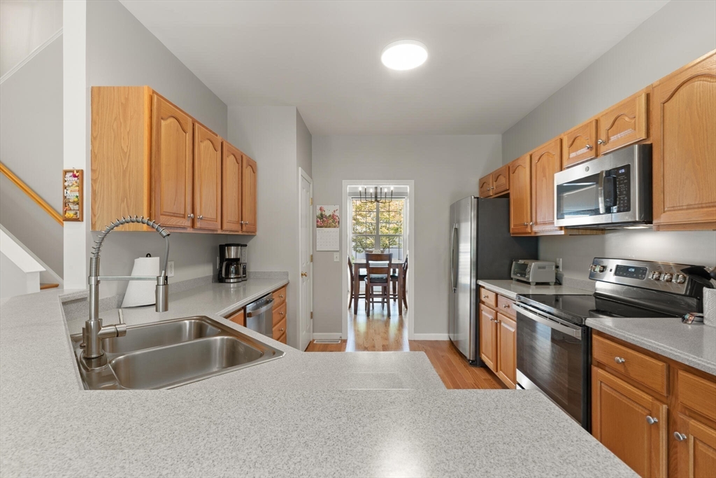 27 Brook Lane, Unit 27 Berlin, MA 01503 - Photo 12 of 36 a kitchen with stainless steel appliances granite countertop a sink stove and refrigerator