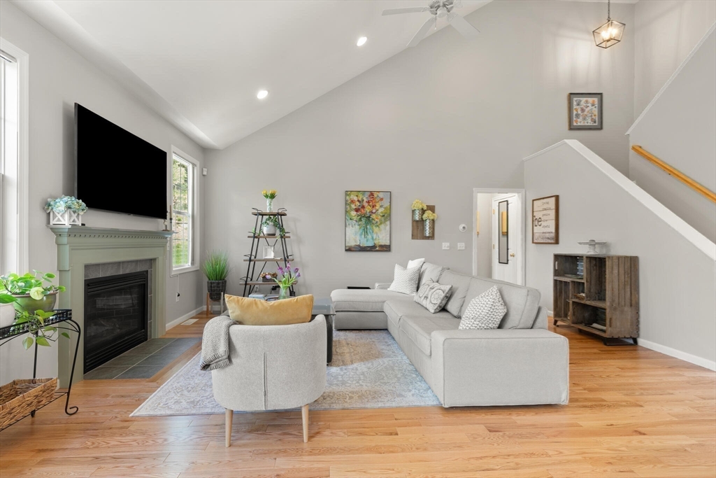 27 Brook Lane, Unit 27 Berlin, MA 01503 - Photo 15 of 36 a living room with furniture a fireplace and a flat screen tv