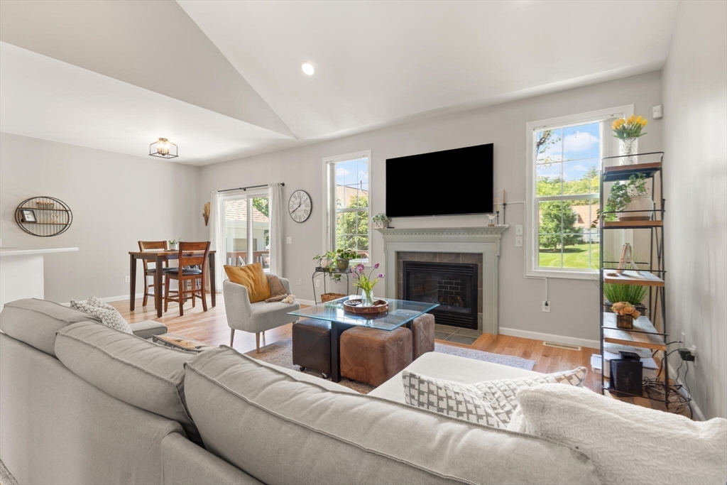 27 Brook Lane, Unit 27 Berlin, MA 01503 - Photo 18 of 36 a living room with furniture a flat screen tv and a fireplace