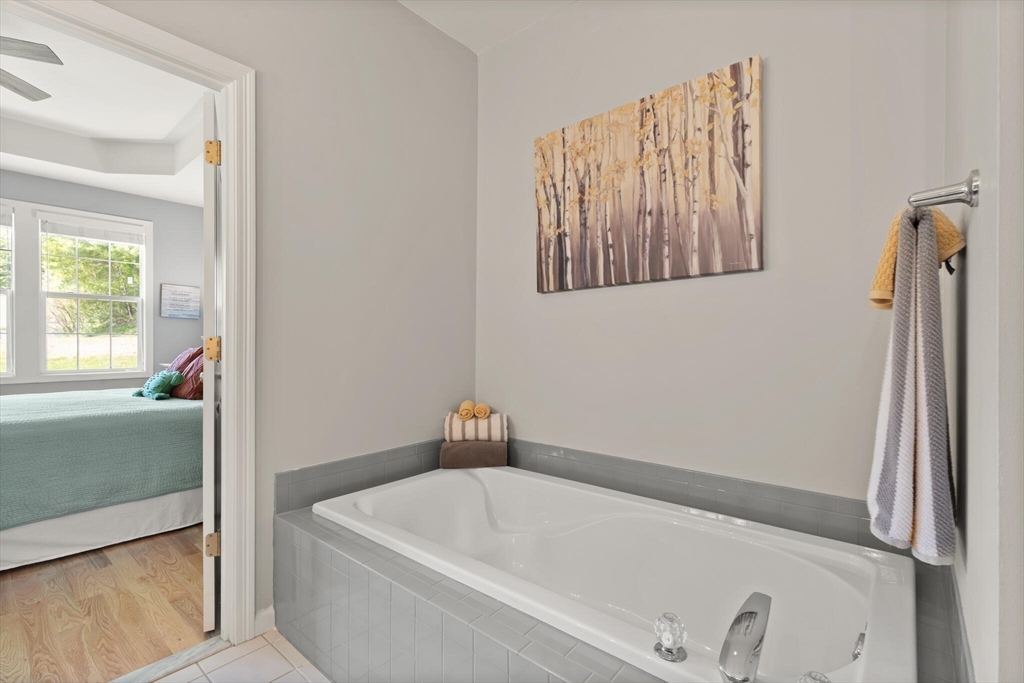 27 Brook Lane, Unit 27 Berlin, MA 01503 - Photo 22 of 36 a bathroom with a tub and a window