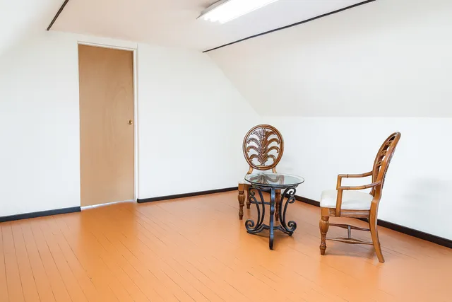 a view of a room with furniture and wooden floor