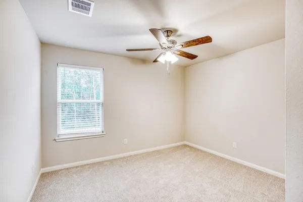 an empty room with a window and a fan