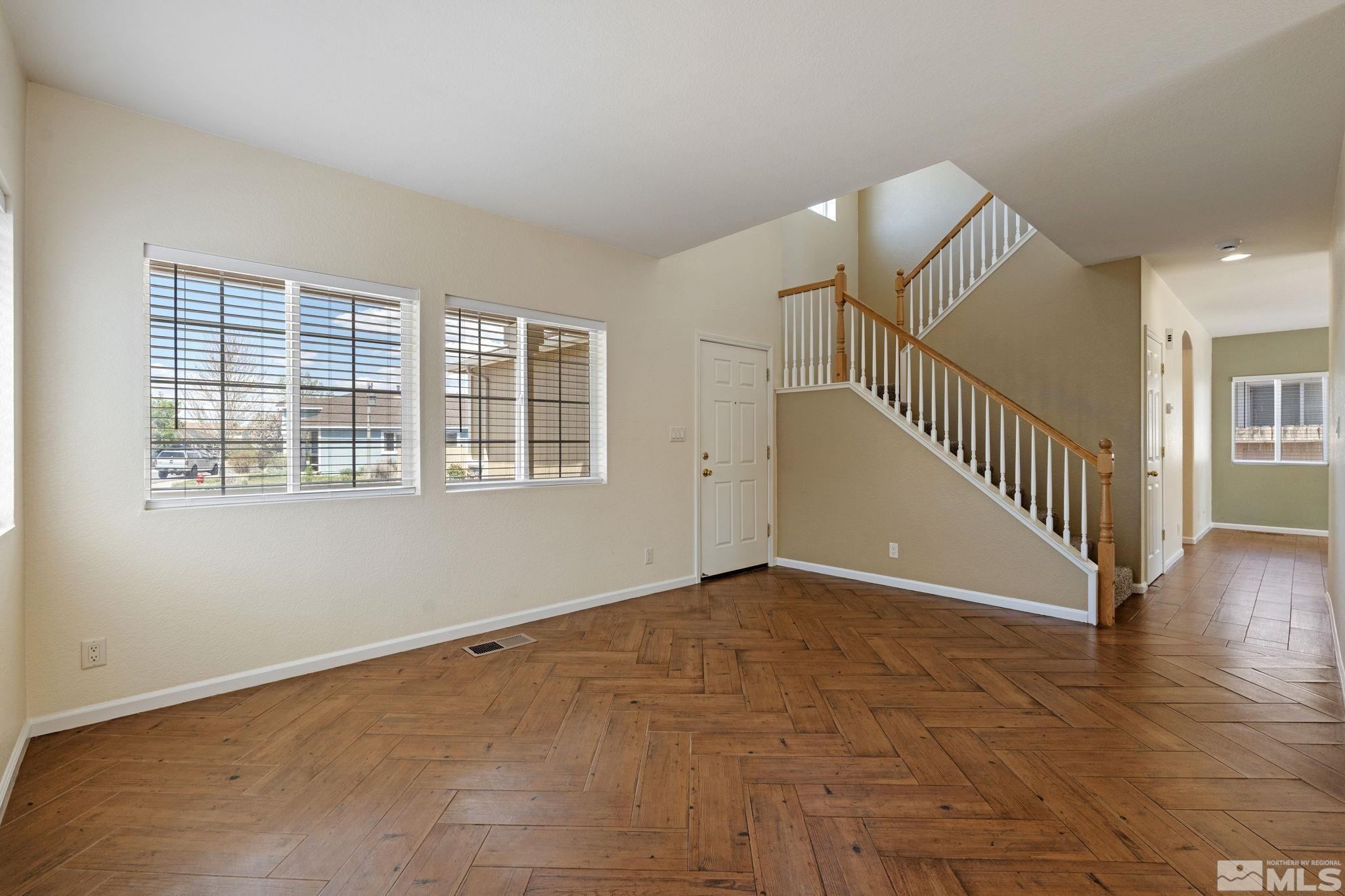10015 Stonefield Drive Reno, NV 89521 - Photo 4 of 35 a view of an empty room with wooden floor and stairs