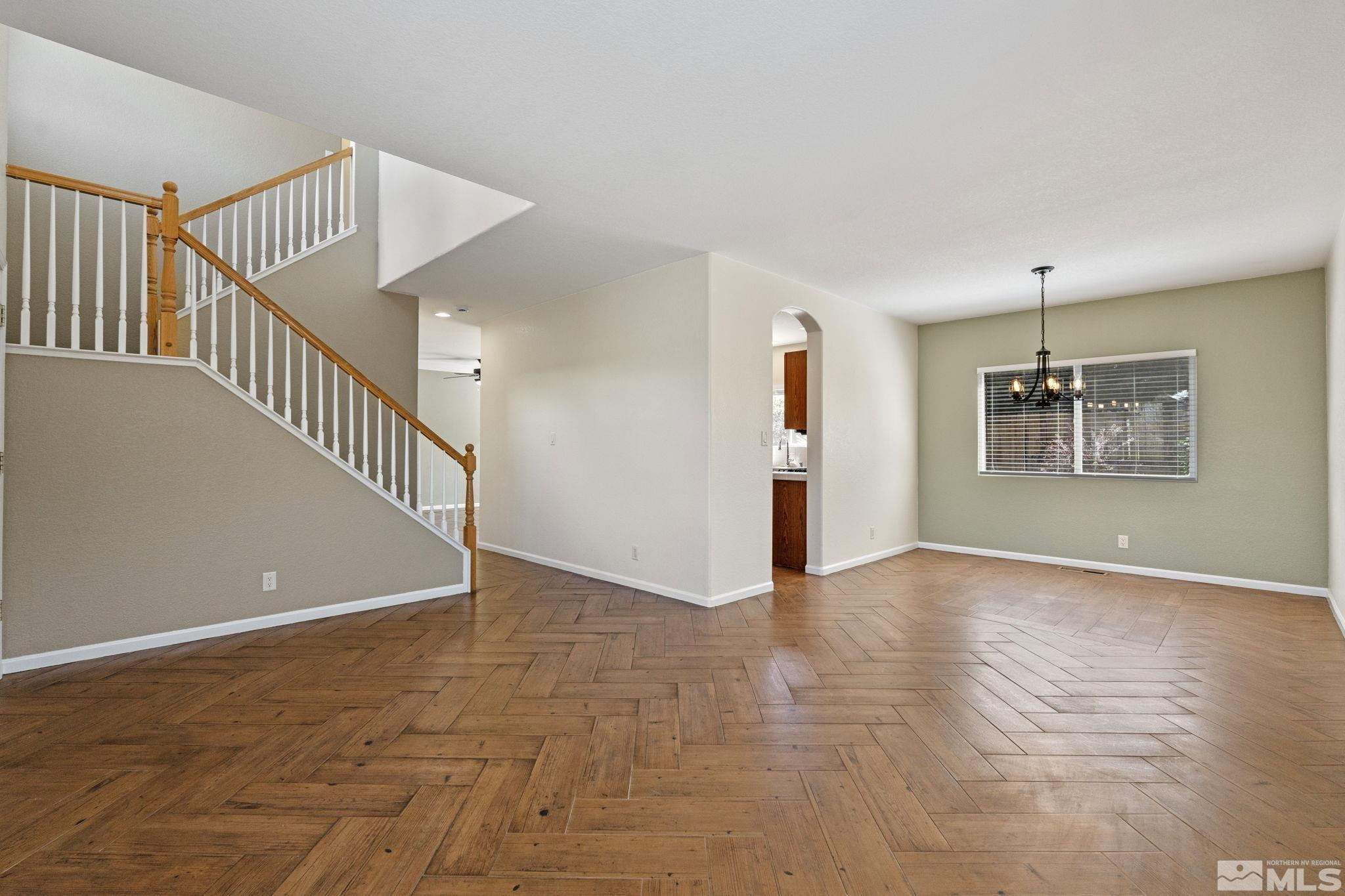 10015 Stonefield Drive Reno, NV 89521 - Photo 6 of 35 a view of an empty room with wooden floor and stairs