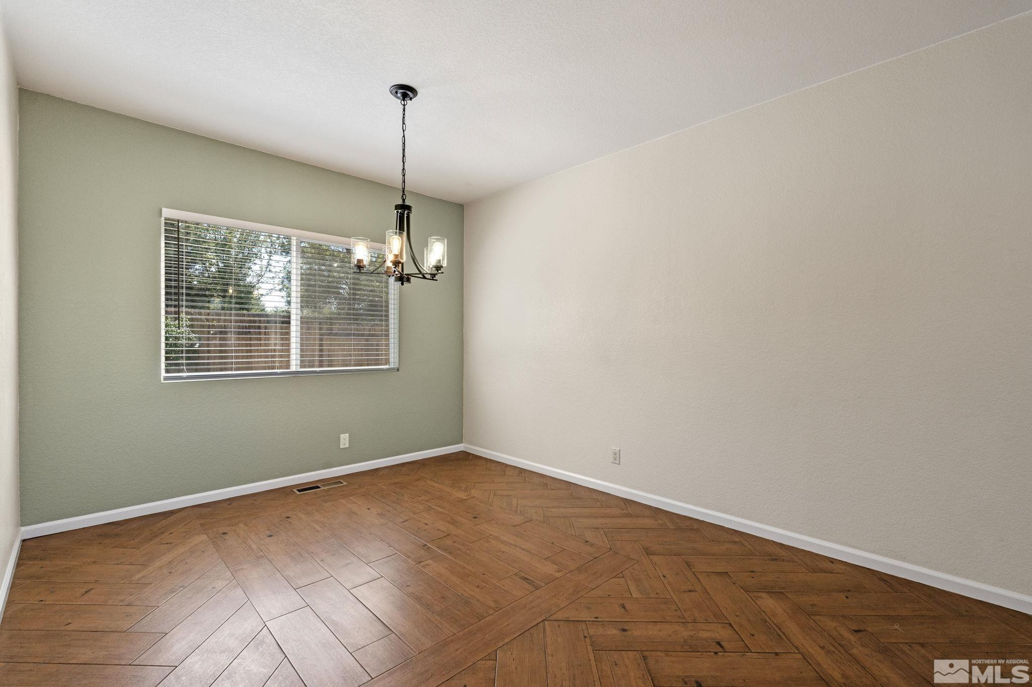 10015 Stonefield Drive Reno, NV 89521 - Photo 8 of 35 a view of an empty room with window and chandelier fan