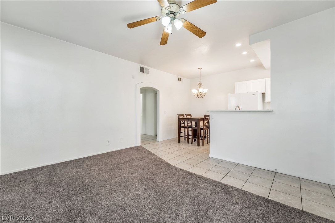 2201 Ramsgate Drive, Unit 811 Henderson, NV 89074 - Photo 11 of 36 An open concept living area transitions from plush carpeting to tiled flooring, leading to a compact dining space.