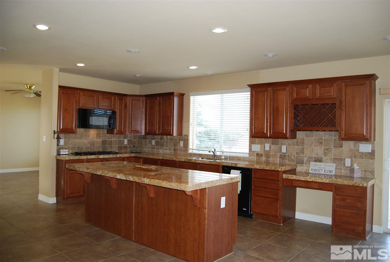 2900 Sandestin Drive Reno, NV 89523 - Photo 12 of 24 a kitchen with stainless steel appliances granite countertop a sink a stove a refrigerator and cabinets