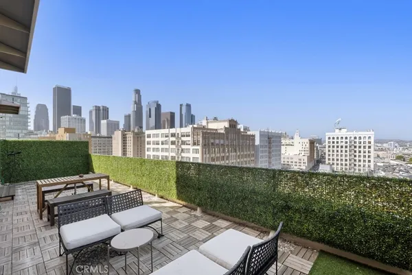 a view of a city from a patio with chairs