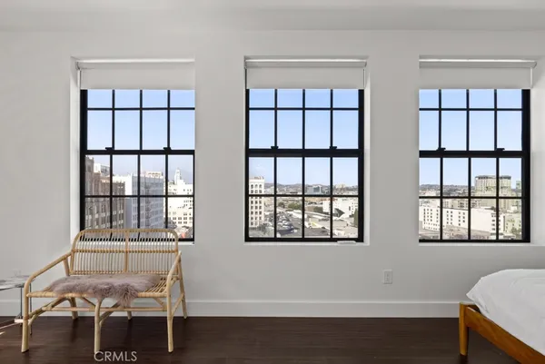 a bedroom with a bed and a window with wooden floor