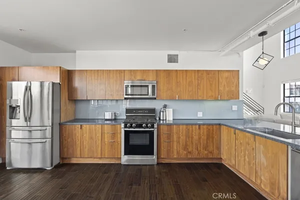 a kitchen with a table chairs and wooden floor