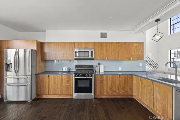 a kitchen with granite countertop stainless steel appliances and wooden cabinets