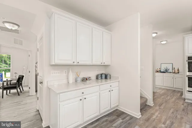 a kitchen with white cabinets and sink