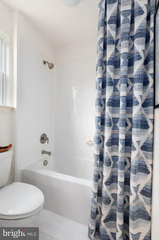 a white toilet sitting next to a bath tub