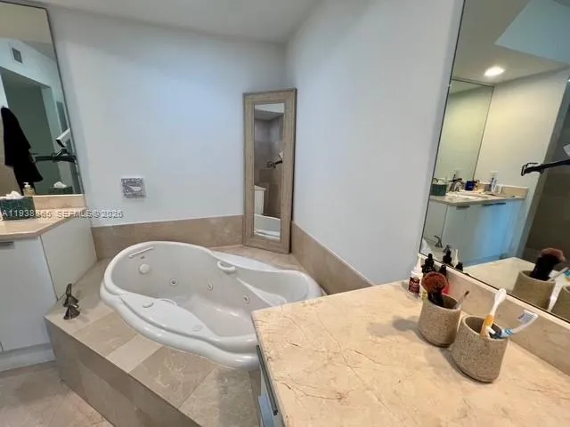 a bathroom with a tub sink and mirror