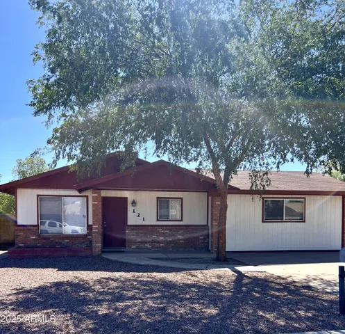 a view of a yard in front of a house with large trees