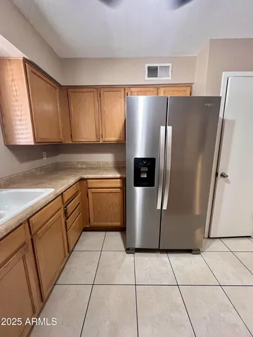 a kitchen with a refrigerator sink and cabinets
