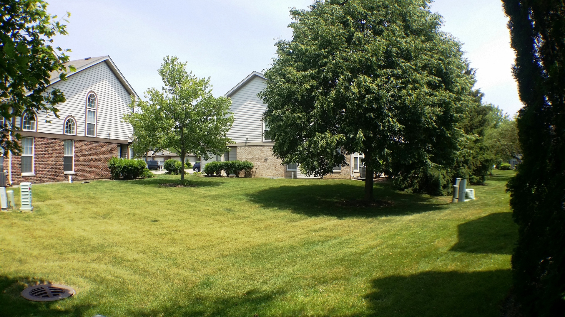 1934 Heron Avenue, Unit D Schaumburg, IL 60193 - Photo 2 of 20 a view of a house with a big yard and large trees