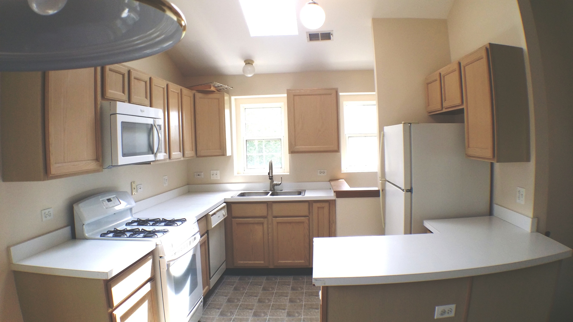 1934 Heron Avenue, Unit D Schaumburg, IL 60193 - Photo 3 of 20 a kitchen with a sink a stove a refrigerator and white cabinets