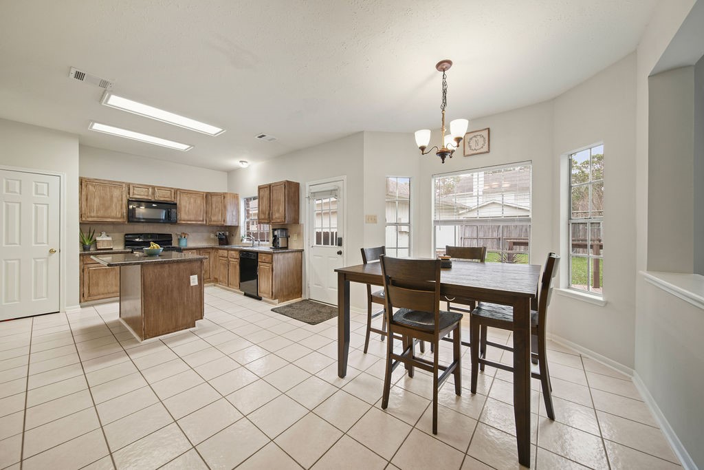 16114 Kintyre Point Road Houston, TX 77095 - Photo 19 of 41 a kitchen with stainless steel appliances kitchen island granite countertop a table chairs and a refrigerator