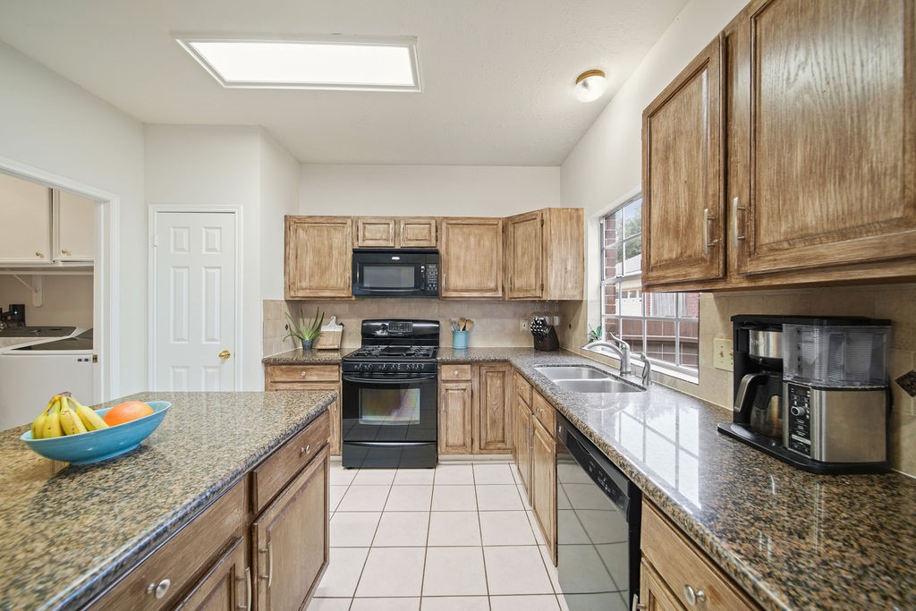 16114 Kintyre Point Road Houston, TX 77095 - Photo 25 of 41 a kitchen with granite countertop stainless steel appliances a stove a sink a microwave and cabinets