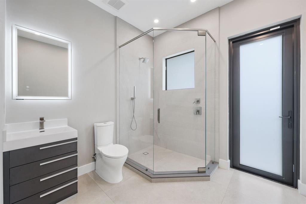 2015 Northeast 4th Avenue Wilton Manors, FL 33305 - Photo 30 of 79 a bathroom with a shower a toilet and a sink