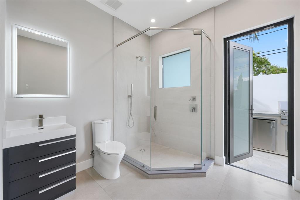 2015 Northeast 4th Avenue Wilton Manors, FL 33305 - Photo 31 of 79 a bathroom with a shower a toilet and a sink