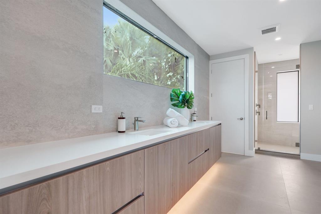 2015 Northeast 4th Avenue Wilton Manors, FL 33305 - Photo 46 of 79 a bathroom with a double vanity sink and a window