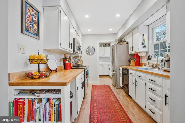 a kitchen with white cabinets and stainless steel appliances