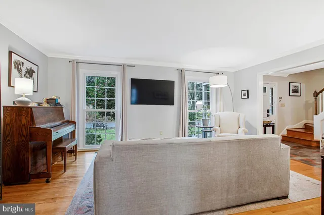a living room with furniture a flat screen tv and a large window