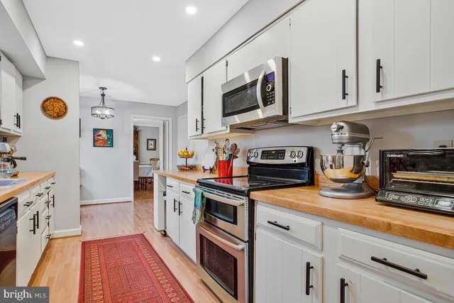 a kitchen with stainless steel appliances granite countertop a lot of counter top space and wooden floor