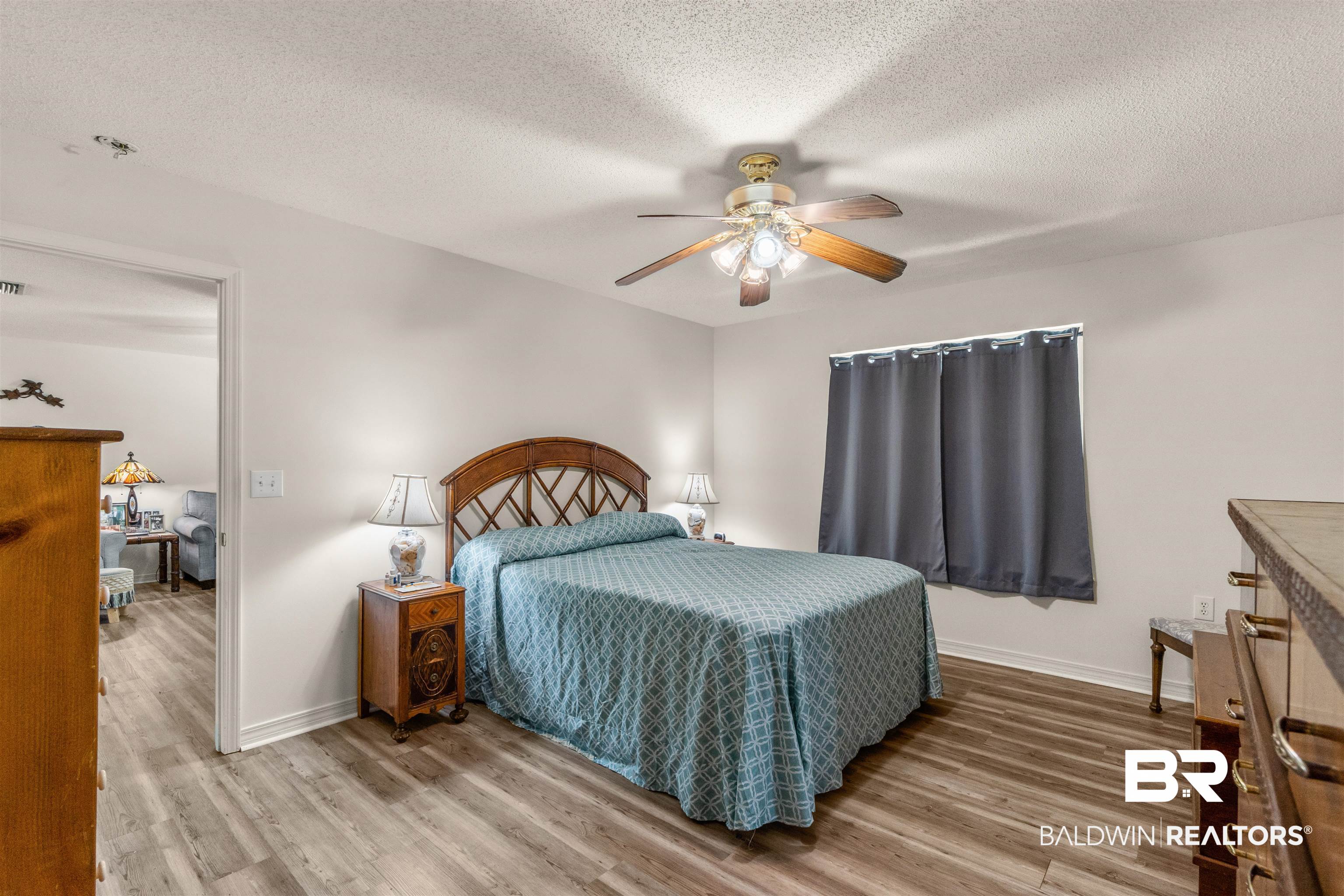 35893 Pine Road South Stapleton, AL 36578 - Photo 14 of 31 Bedroom featuring wood-finish flooring, a ceiling fan with integrated lighting, and a window with dark curtain rods