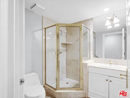 a bathroom with a granite countertop toilet sink and mirror
