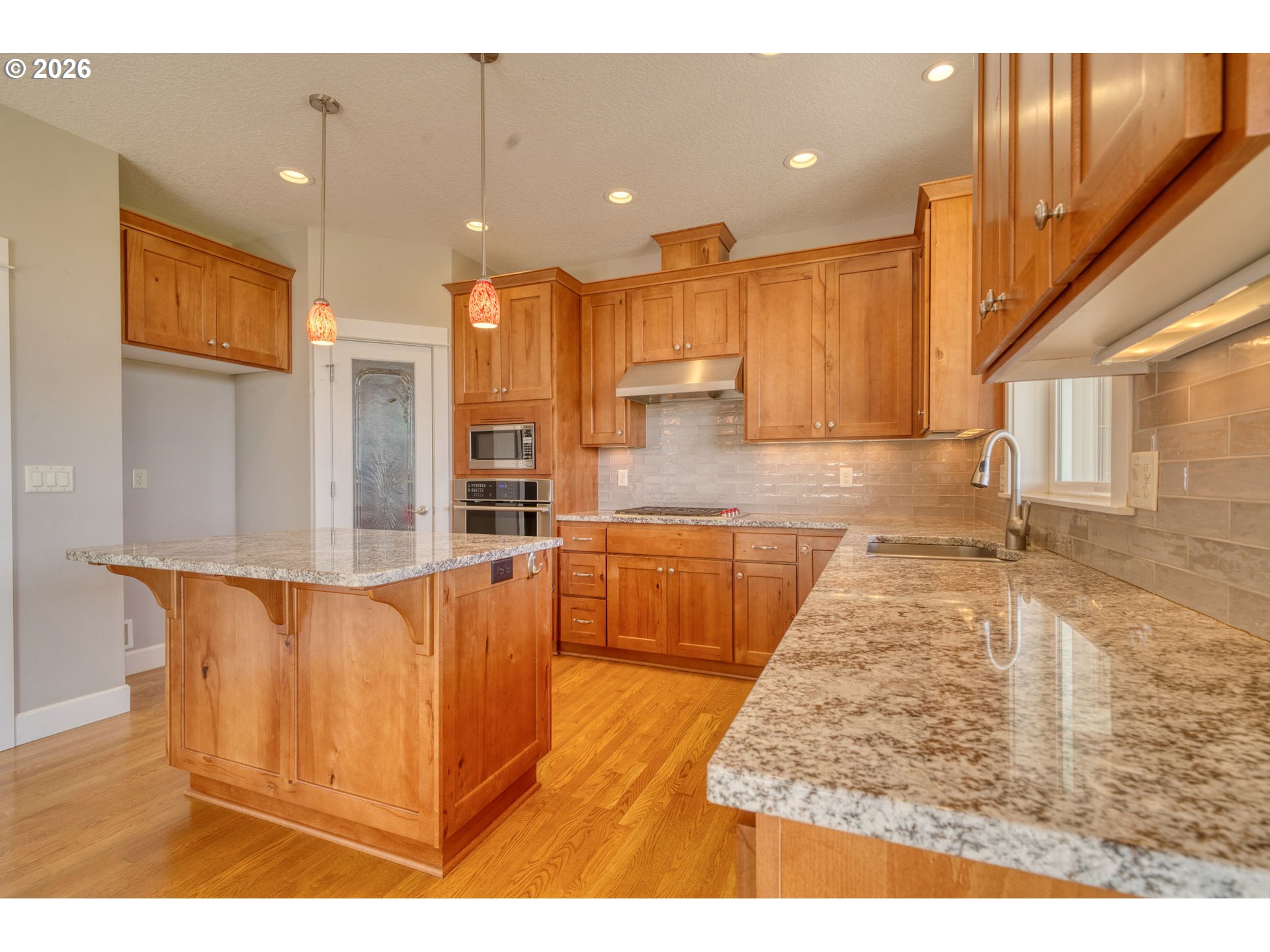 33058 Church Road Warren, OR 97053 - Photo 13 of 45 a large kitchen with kitchen island granite countertop a sink and a view of living room