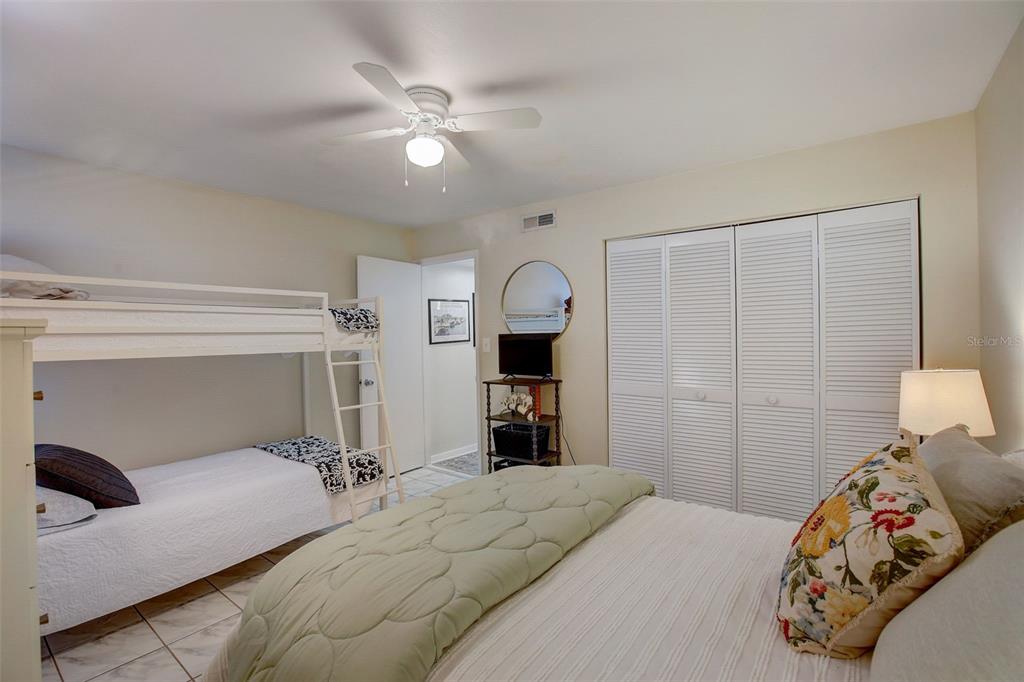 103 Cypress Pond Road, Unit 103 Palm Harbor, FL 34683 - Photo 11 of 52 a bedroom with a large bed and a chandelier