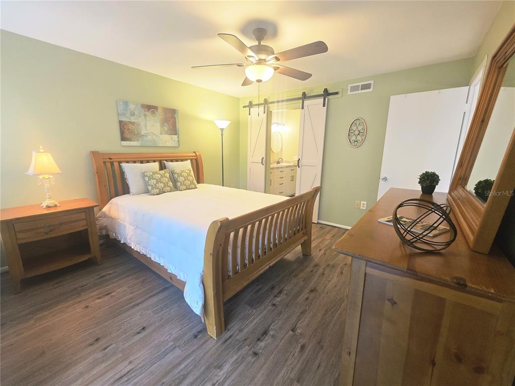 103 Cypress Pond Road, Unit 103 Palm Harbor, FL 34683 - Photo 29 of 52 a bedroom with a bed and wooden floor