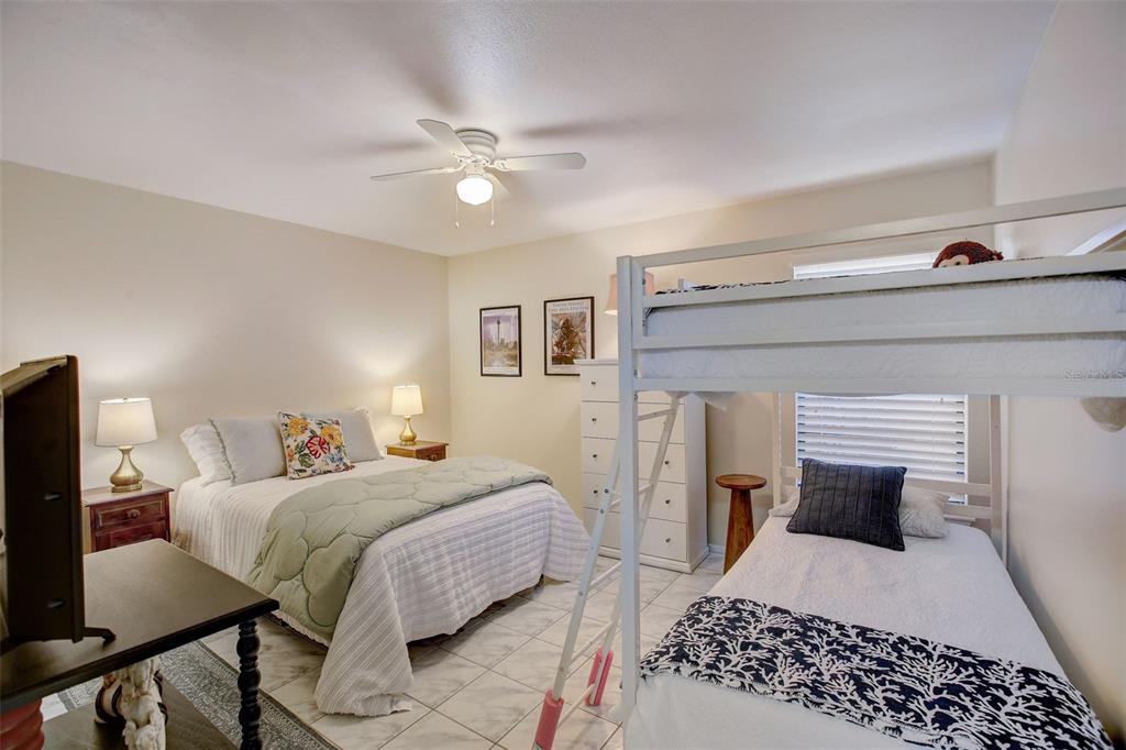 103 Cypress Pond Road, Unit 103 Palm Harbor, FL 34683 - Photo 34 of 52 a bedroom with a bed and a chandelier