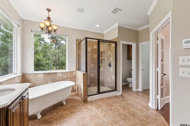 a spacious bathroom with a tub shower and window