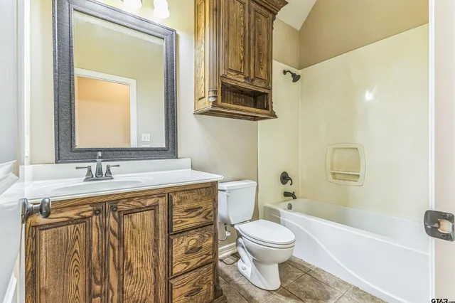 a bathroom with a sink a toilet and a mirror