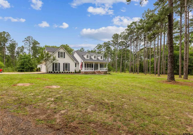a view of a house with yard and tree s