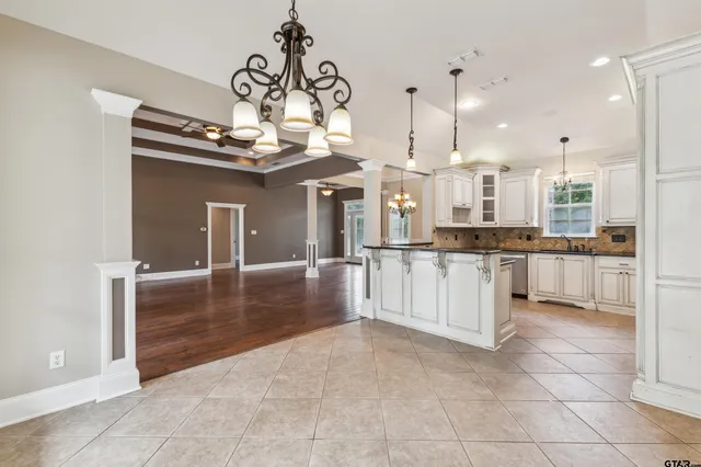 a large white kitchen with kitchen island granite countertop a large counter top and white cabinets